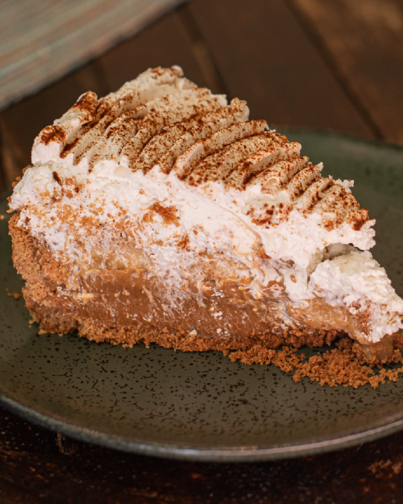 Banana, doce de leite e chantilly sobre base crocante.